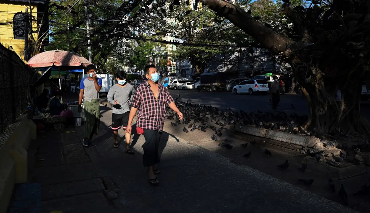 Orang-orang berjalan di sepanjang jalan setapak sehari setelah militer Myanmar merebut kekuasaan, Yangon, Myanmar, Selasa (2/2/2021). Militer Myanmar menahan pemimpin yang terpilih secara demokratis Aung San Suu Kyi dan memberlakukan keadaan darurat satu tahun. (STR/AFP)