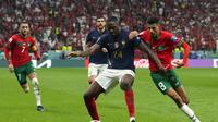 Bek Prancis, Ibrahima Konate melindungi bola dari kejaran para pemain Maroko dalam laga semifinal Piala Dunia 2022. (AP Photo/Francisco Seco)