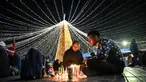 Keluarga-keluarga menyalakan lilin pada Hari Lilin Kecil ('Dia de las velitas'), di Bogota pada tanggal 7 Desember 2023. (Juan BARRETO/AFP)