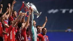 Penjaga gawang Bayern Munchen, Manuel Neuer (tengah), dan rekan satu timnya berselebrasi mengangkat trofi setelah mengalahkan PSG pada final Liga Champions di stadion Luz di Lisbon (23/8/2020). Munchen menang tipis atas PSG 1-0. (AFP/Pool/David Ramos)