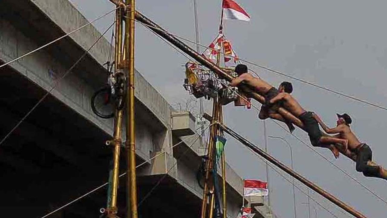 FOTO: Serunya Lomba Panjat Pinang Berhadiah Emas di Aliran Kalimalang, Gagal Jaga Keseimbangan Auto Nyebur