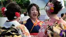 Sejumlah gadis Jepang mengenakan kimono berkumpul untuk upacara Coming of Age Day atau Hari Kedewasaan di Tokyo Disneyland, di Urayasu, Senin (13/1/2020). Coming of Age Day atau Hari Kedewasaan ini menandakan diperbolehkannya merokok, mengonsumsi alkohol dan mengikuti Pemilu. (Kazuhiro NOGI/AFP)