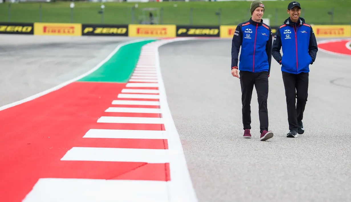Pembalap Indonesia dari tim Scuderia Toro Rosso, Sean Geleal (kanan) dan rekannya Brendon Hartley berjalan jelang Grand Prix F1 AS di Austin (18/10). Sean Geleal akan latihan bebas pada hari Jumat (19/10/2018) tengah malam WIB. (AFP Photo/Peter Fox)