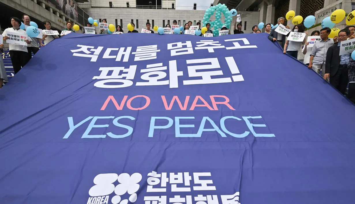 Para aktivis Korea Selatan memegang spanduk besar bertuliskan "No War, Yes Peace" dalam sebuah unjuk rasa di Seoul pada tanggal 25 Juni 2024. (Jung Yeon-je/AFP)