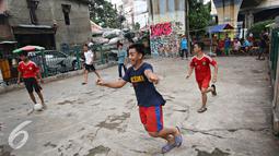 Ekspresi salah satu remaja saat bermain sepak bola di kolong rel kereta kawasan Juanda, Jakarta, Jumat (27/5). Tidak tersedianya ruang terbuka menyebabkan lahan tersebut dijadikan tempat bersosialisasi bagi warga. (Liputan6.com/Immanuel Antonius)