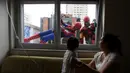 Petugas pembersih kaca menggunakan kostum Spiderman dan Iron Man menghibur pasien anak yang dirawat di RS Infantil Sabara, Sao Paulo, Senin (10/10). Aksi ini bagian dari perayaan Hari Anak Brasil yang diperingati tiap 12 Oktober. (REUTERS/Paulo Whitaker)