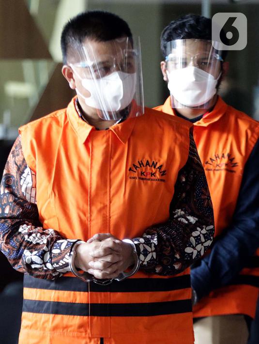 Bupati Bandung Barat Aa Umbara Sutisna (depan) dan anaknya Andri Wibawa usai menjalani pemeriksaan di Gedung KPK, Jakarta, Jumat (9/4/2021). KPK menahan keduanya terkait dugaan korupsi pengadaan barang tanggap darurat pandemi COVID-19 pada Pemkab Bandung Barat 2020. (Liputan6.com/Helmi Fithriansyah)