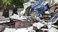 Para pekerja memeriksa puing-puing setelah gempa bumi di daerah Luxian di provinsi Sichuan China barat daya, Kamis (16/9/2021). Gempa bumi meruntuhkan rumah, menewaskan tiga orang dan melukai belasan lainnya. (Chinatopix Via AP)
