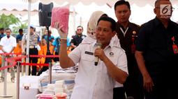 Kepala BNN Budi Waseso memberi keterangan sambil menunjukkan barang bukti narkotika saat pemusnahan di Bandara Soekarno Hatta, Banten, Kamis (28/12). Barang bukti yang dimusnahkan yaitu 453,56 kg shabu, 712,116 butir ekstasi. (Liputan6.com/JohanTallo)