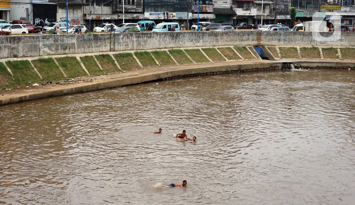 Anak-anak berenang di aliran Sungai Ciliwung, Jatinegara, Jakarta Timur, Sabtu (4/7/2020). Minimnya lahan bermain menyebabkan anak-anak tersebut bermain tidak pada tempatnya, meski dapat membahayakan keselamatan. (Liputan6.com/Immanuel Antonius)