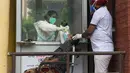 Petugas kesehatan mengambil sampel swab seorang wanita untuk menguji virus corona Covid-19 di sebuah rumah sakit di Amritsar (2/9/2020). (AFP/Narinder Nanu)