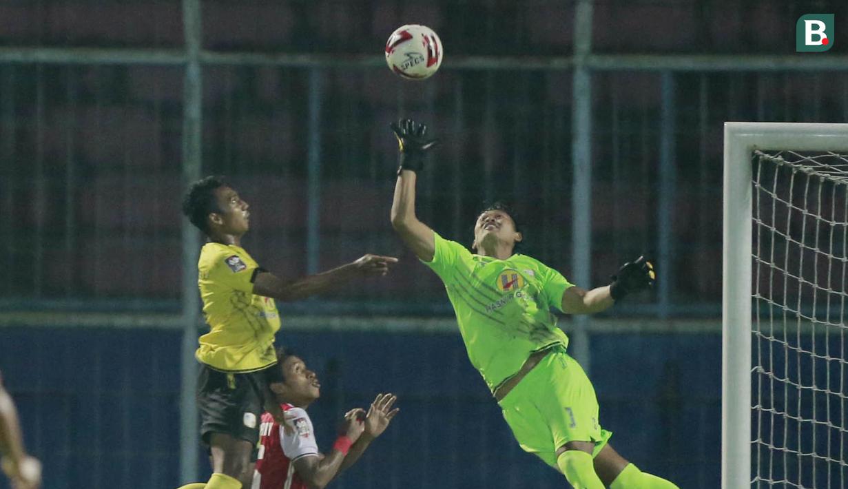 Kiper Barito Putera, Muhammad Riyandi (kiri), berusaha menghalau bola saat melawan Persija Jakarta pada laga perempat final Piala Menpora 2021 di Stadion Kanjuruhan, Malang, Sabtu (10/4/2021). Persija menang dengan skor 1-0. (Bola.com/Arief Bagus)