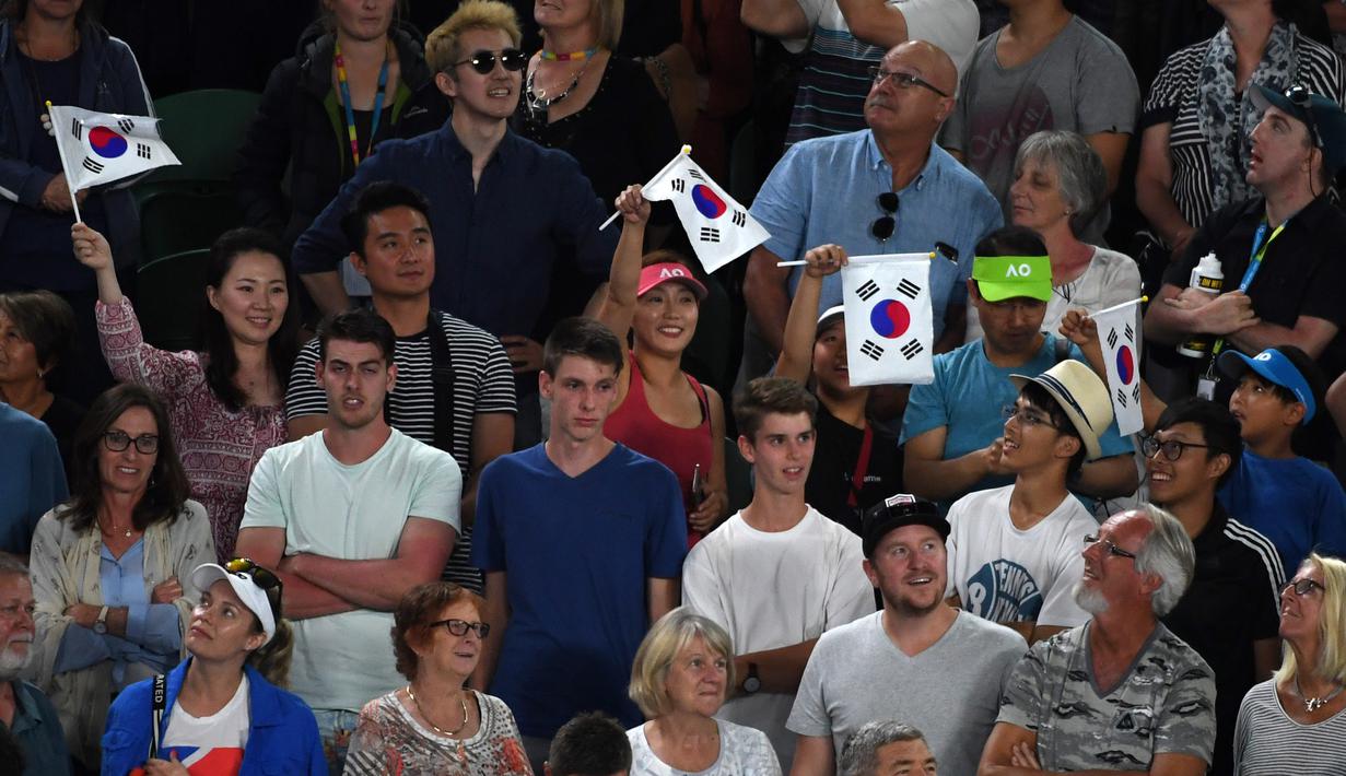 Suporter mengibarkan bendera Korea Selatan saat mendukung Hyeon Chung meawan Novak Djokovic pada ajang Australia Terbuka 2018 di Melbourne,  (22/2/2018). Djokovic kalah 6-7, 5-7, 6-7. (AFP/William West)