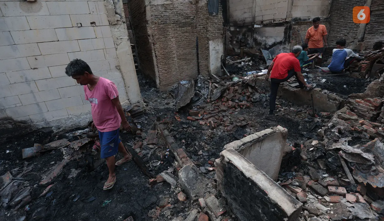 Warga memilah barang-barang yang tersisa di antara puing bangunan pascakebakaran di kawasan permukiman Jalan Kramat Pulo Dalam, Senen, Jakarta Pusat, Jumat (9/10/2026). (KLY/Budy Santoso)