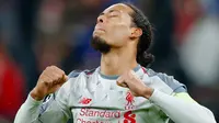 Bek Liverpool, Virgil Van Dijk berselebrasi setelah menang atas Bayern Munchen pada leg kedua babak 16 besar Liga Champions di Allianz Arena, Rabu (13/3). Liverpool lolos ke perempat final setelah menang 3-1 atas Bayern Munchen. (AP/Matthias Schrader)