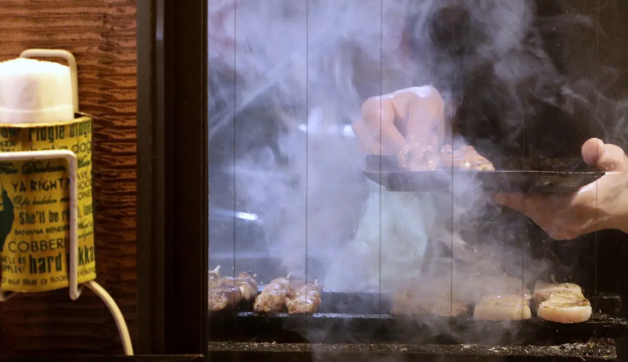 Yakitori saat dibakar di sebuah bar di area jalan malam belakang pusat kota Tokyo (4/10/2019). Yakitori terbuat dari potongan daging semua bagian ayam seperti dada, paha , kulit, hati dan jeroan lainnya dan dimasak di atas arang. (AP Photo/Mark Baker)