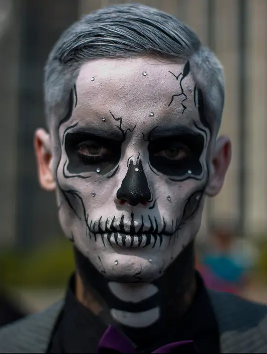 Seorang pria berpose dengan kostum dan dandanan menyerupai zombie dalam acara Zombie Walk di Sao Paulo, Brasil, Jumat (2/11). Ribuan orang beraksi sebagai Zombie untuk memeriahkan peringatan Hari Para Arwah yang diadakan sejak 2006. (Mauro PIMENTEL/AFP)