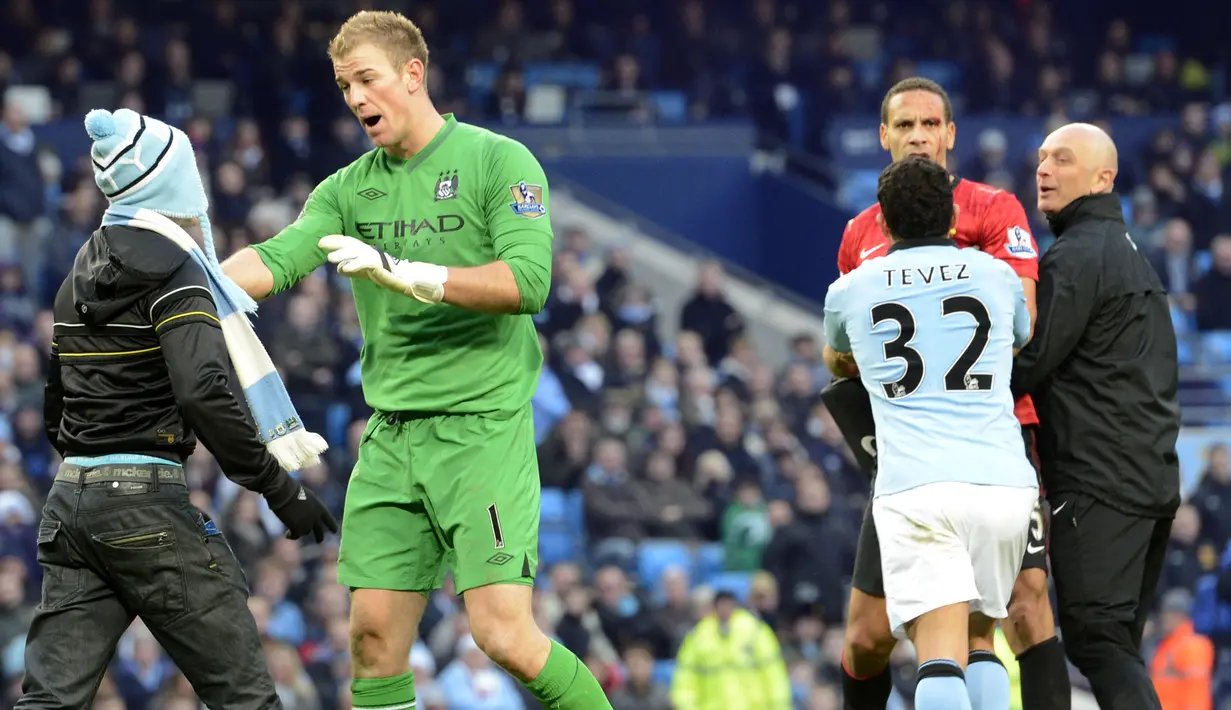 Joe Hart (kiri) berusaha menenangkan emosi fan The Citizens yang menyusup saat Derbi Manchester berlangsung di Etihad Stadium pada 2012 lalu. ( AFP/Paul Ellis )