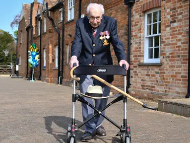 Veteran Perang Dunia II Kapten Tom Moore (99) berjalan di kebunnya di Marston Moretaine, London, 16 April 2020. Moore mengumpulkan donasi lebih dari 16 juta dolar untuk National Health Service (NHS) dengan berjalan 100 kali bolak-balik jarak 25 meter di taman belakang rumahnya. (Justin TALLIS/AFP)