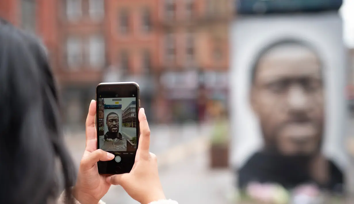 Seseorang mengabadikan foto mural George Floyd di Manchester tengah, Inggris (4/6/2020). George Floyd tewas kehabisan napas saat dalam penahanan pihak kepolisian Negara Bagian Minnesota, wilayah Midwest Amerika Serikat, pada pekan lalu. (Xinhua/Jon Super)