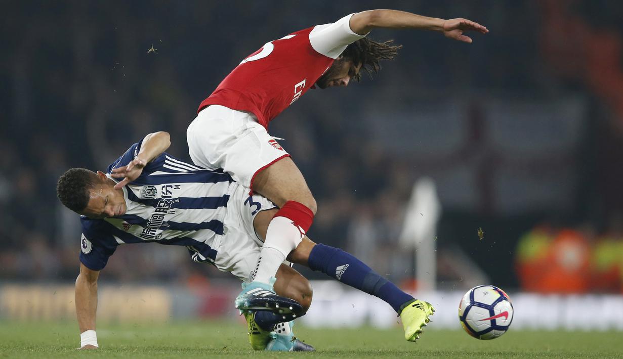 Pemain West Bromwich Albion, Kieran Gibbs (kiri) berusaha merebut bola dari kaki pemain Arsenal, Mohamed Elneny pada lanjutan Premier League di Emirates stadium, London (25/9/2017). Arsenal menang 2-0. (AP/Alastair Grant)
