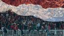Suporter Timnas Indonesia mengibarkan bendera raksasa saat melawan Thailand pada laga Final Piala AFF 2016 di Stadion Pakansari, Bogor, (14/12/2016). (Bola.com/Nicklas Hanoatubun)