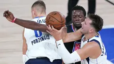 Pebasket Dallas Mavericks, Luka Doncic, berebut bola dengan pemain Los Angeles Clippers, Reggie Jackson, pada gim kedua playoff NBA 2020 di AdventHealth Arena, Kamis (20/8/2020). Maverick menang 127-114 atas LA Clipppers. (AFP/Ashley Landis-Pool/Getty Images)