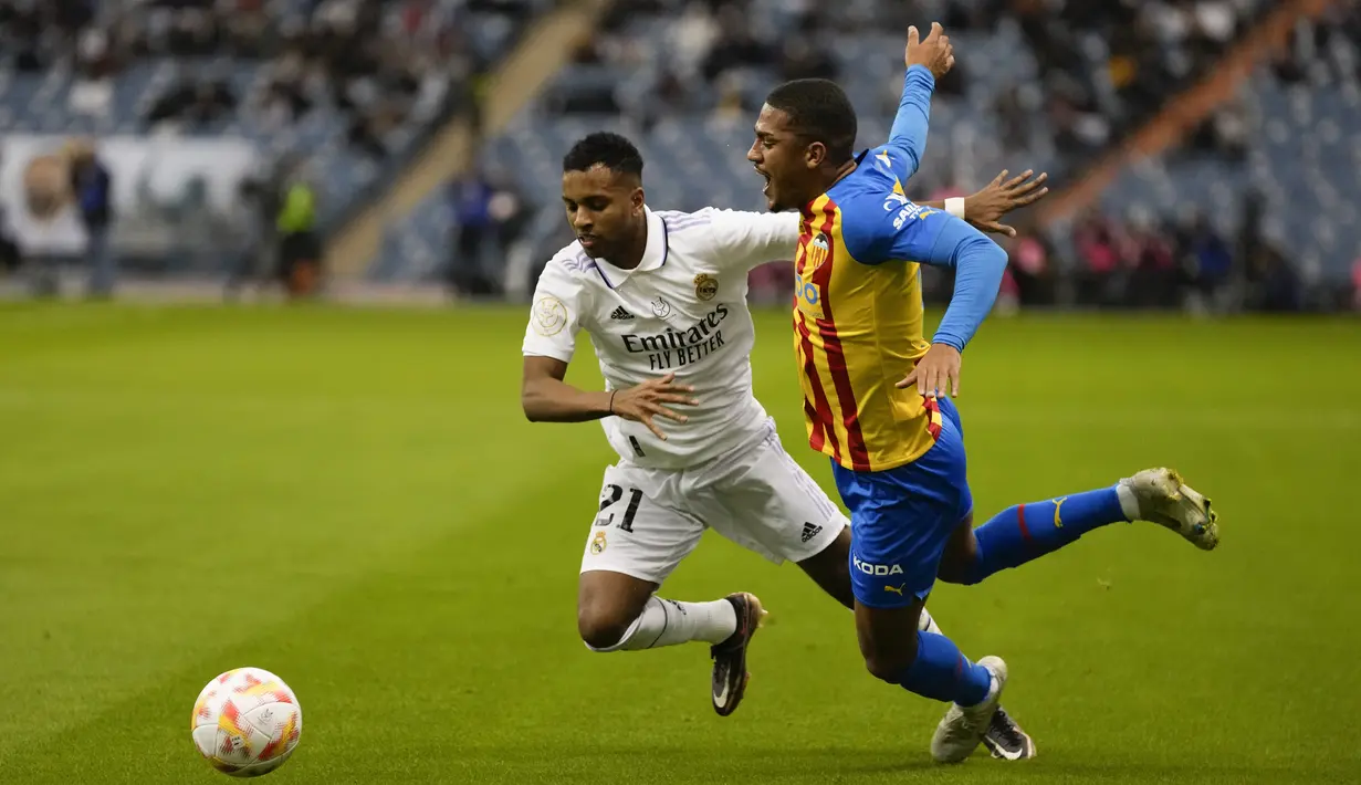 Penyerang Real Madrid, Rodrygo berebut bola dengan pemain Valencia, Nico Gonzalez pada pertandingan semifinal Piala Super Spanyol di Stadion Internasional King Fahd di Riyadh, Arab Saudi, Kamis (12/1/2023). Kemenangan tersebut membuat Los Blancos melaju ke final Piala Super Spanyol 2023. (AP Photo/Hussein Malla)