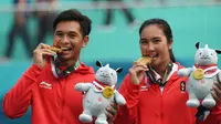 Petenis ganda campuran Indonesia Christopher Rungkat (kiri) dan Aldila Sutjiadi menggigit medali emas pada upacara penganugerahan medali seusai menang atas petenis Thailand Luksika Kumkhum dan Sonchat Ratiwatana pada final tenis ganda campuran Asian Games