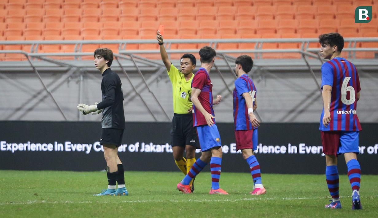 Kiper Atletico Madrid U-18, Luciano Riveros Garcia (kiri) mendapatkan kartu merah oleh Wasit saat laga International Youth Championship 2021 antara Barcelona U-18 melawan Atletico Madrid U-18 di Jakarta International Stadium, Jakarta, Jumat (15/04/2022). (Bola.com/Bagaskara Lazuardi)