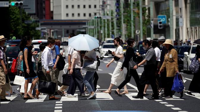 Orang-orang menyeberang jalan di Tokyo, Jepang, Kamis (2/7/2020). Jepang mengangkat darurat pandemi selama tujuh minggu pada akhir Mei, sebagian besar kegiatan sosial dan bisnis sejak itu telah kembali dimulai. (AP Photo/Eugene Hoshiko)
