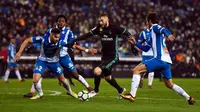 Pemain Real Madrid, Karim Benzema berebut bola dengan pemain Espanyol Marc Granero dan Granero pada pertandingan pekan ke-26 La Liga, di Stadion RCDE, Selasa (27/2). Real Madrid harus menyerah dari Espanyol dengan skor akhir 0-1. (Josep LAGO / AFP)