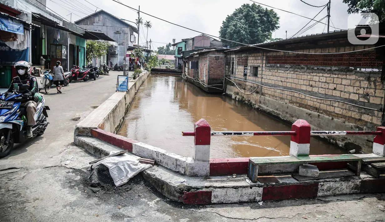Pengendara motor melintas dekat bantaran Kali Induk Kramat Jati, Jakarta, Rabu(18/5/2022). Pemprov DKI Jakarta melalui Dinas Sumber Daya Air (SDA) berencana akan menormalisasi Kali Induk secara keseluruhan guna mencegah banjir yang melanda kawasan tersebut saat hujan deras mengguyur. (Liputan6.com/FaizaL Fanani)