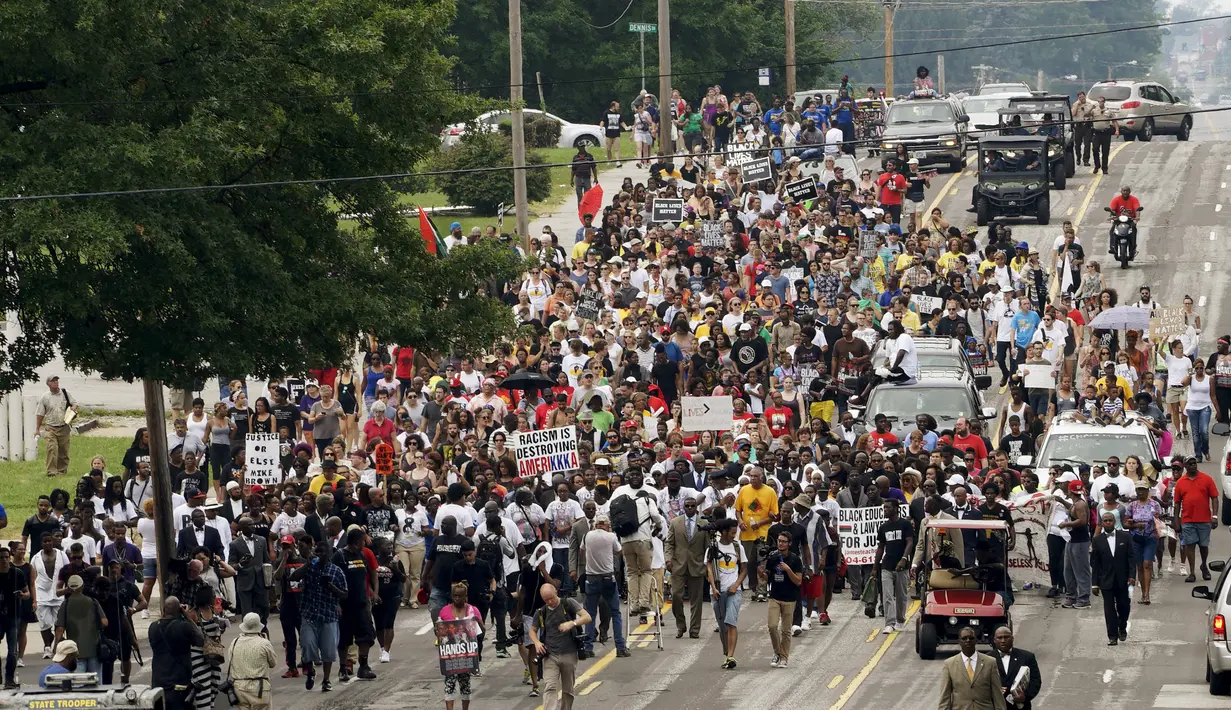 Ratusan orang turun ke jalan untuk memperingati satu tahun pembunuhan remaja kulit hitam yang tidak bersenjata, Michael Brown oleh polisi berkulit putih yang memicu kerusuhan besar, di Ferguson, New York, Minggu (9/8/2015). (REUTERS/Rick Wilking)