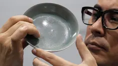 Staf Balai Lelang Sotheby menunjukkan mangkuk berusia 1.000 tahun dari Dinasti Song di Hong Kong, Selasa (3/10). Terjual sekitar Rp510,4 miliar, mangkuk berdiameter 13 cm itu memecahkan rekor lelang dunia untuk barang-barang keramik China. (AP/Kin Cheung)