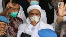 Rizieq Shihab (tengah) memberi keterangan sesaat sebelum masuk gedung utama Mapolda Metro Jaya, Jakarta, Sabtu (12/12/2020). Rizieq Shihab akan menjalani pemeriksan sebagai tersangka penghasutan dan kerumunan di tengah pandemi Covid-19. (Liputan6.com/Helmi Fithriansyah)