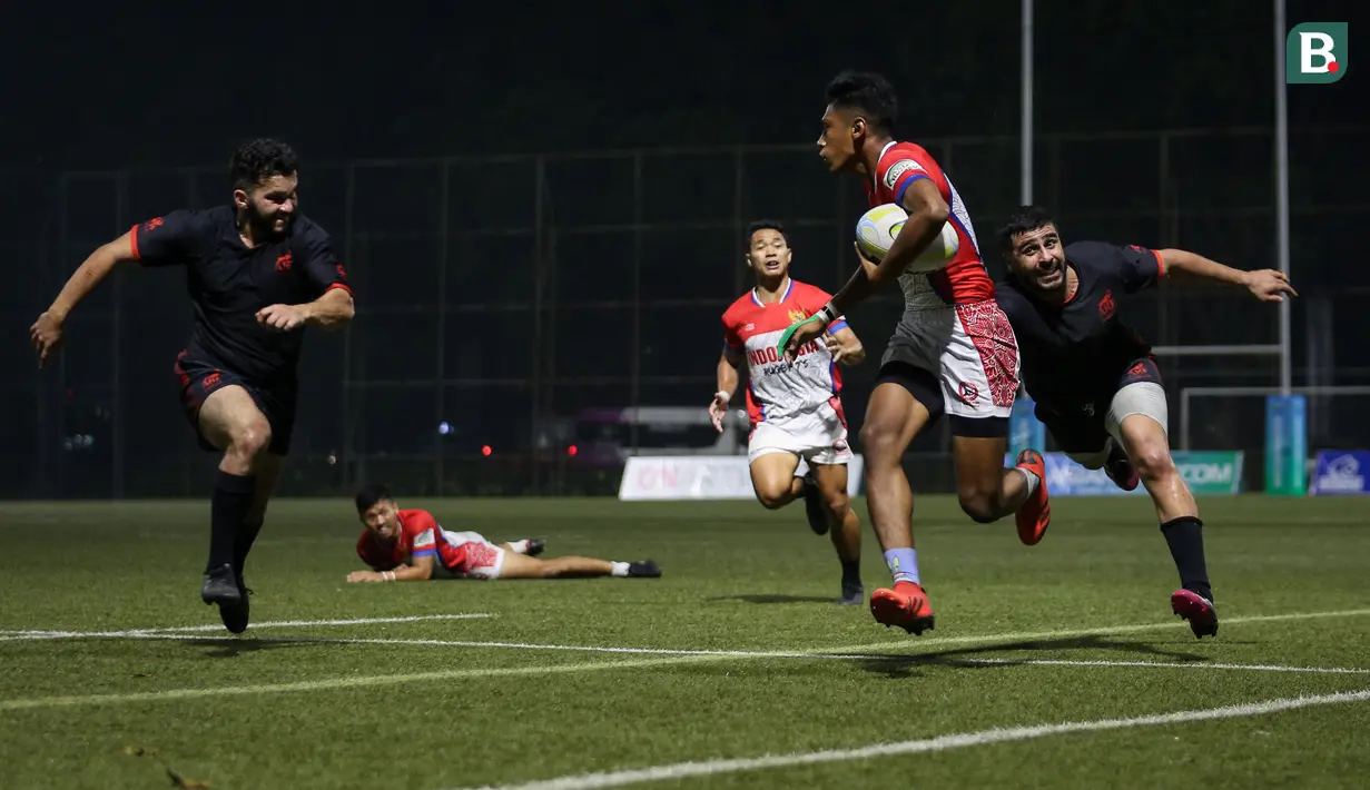 Pemain tim rugby putra Indonesia, Imran Satria Abadi berusaha melepaskan diri dari kejaran pemain tim rugby putra Afganistan saat laga Asia Rugby Sevens Trophy 2022 yang berlangsung di GBK Rugby Field, Jakarta, Sabtu (06/08/2022). (Bola.com/Bagaskara Lazuardi)