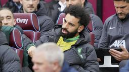 Striker Liverpool, Mohamed Salah duduk di bangku cadangan jelang dimulainya laga pekan ke-35 Premier League 2023/2024 menghadapi West Ham United di London Stadium, London, Sabtu (27/4/2024). (PA via AP Photo/Jonathan Brady)