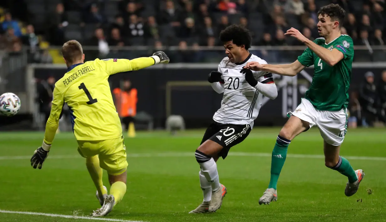 Gelandang Timnas Jerman, Serge Gnabry berebut bola dengan pemain Irlandia Utara Tom Flanagan pada laga Grup C Kualifikasi Piala Eropa 2020 di Commerzbank Arena, Selasa (19/11/2019). Timnas Jerman benamkan Irlandia Utara dengan skor telak 6-1 berkat bantuan hat-trick dari Gnabry. (AP/Michael Probst)
