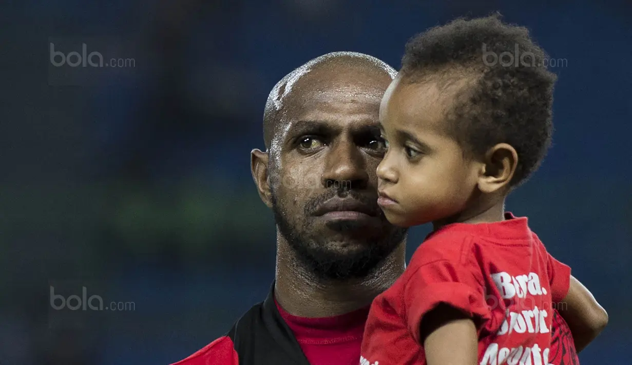 Kapten Persipura, Boaz Solossa, menggendong sang putri sebelum bertanding melawan Bhayangkara FC pada laga Liga 1 Indonesia di Stadion Patriot, Bekasi, Sabtu (9/9/2017). Bhayangkara FC menang 2-1 atas Persipura. (Bola.com/Vitalis Yogi Trisna)