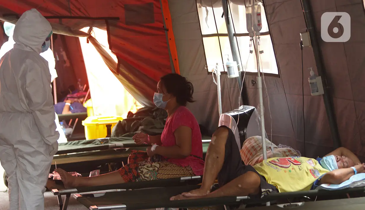 Petugas medis berbincang dengan pasien COVID-19 di ruang IGD (Instalasi Gawat Darurat) di RSUD Bekasi, Rabu (23/6/2021). Pemkot Bekasi mendirikan tenda untuk ruang IGD yang dapat menampung 30 pasien karena keterisian tempat tidur penuh akibat lonjakan kasus COVID-19. (Liputan6.com/Herman Zakharia)