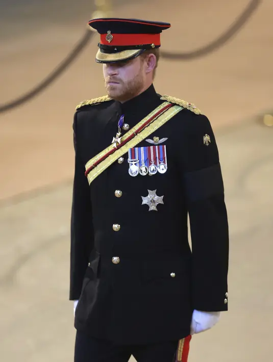 Pangeran Harry ditugaskan untuk berjaga di sekitar peti jenazah Ratu Elizabeth II di Westminster Hall, di Istana Westminster, London, Sabtu (17/9/2022). Atas permintaan Raja Charles, Pangeran Harry mengenakan seragam militernya untuk pertama kalinya sejak 2020. (Chris Jackson/Pool Photo via AP)