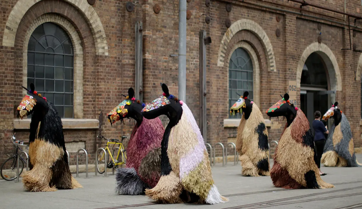 Para penari mengenakan kostum menyerupai kuda karya Nick Cave berjalan di kota Sydney, Australia (8/11).  Kostum ini terinspirasi dari tekstil Tibet dan pakaian upacara tradisional Afrika. (Reuters/Jason Reed)