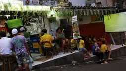Di pemukiman kumuh, Pavao-Pavaozinho, Rio de Janeiro, warga berkumpul di salah satu toko yang menyediakan televisi berikut layar lebar untuk melihat aksi Neymar dkk berlaga melawan Kamerun, (23/6/2014). (REUTERS/Ricardo Moraes)
