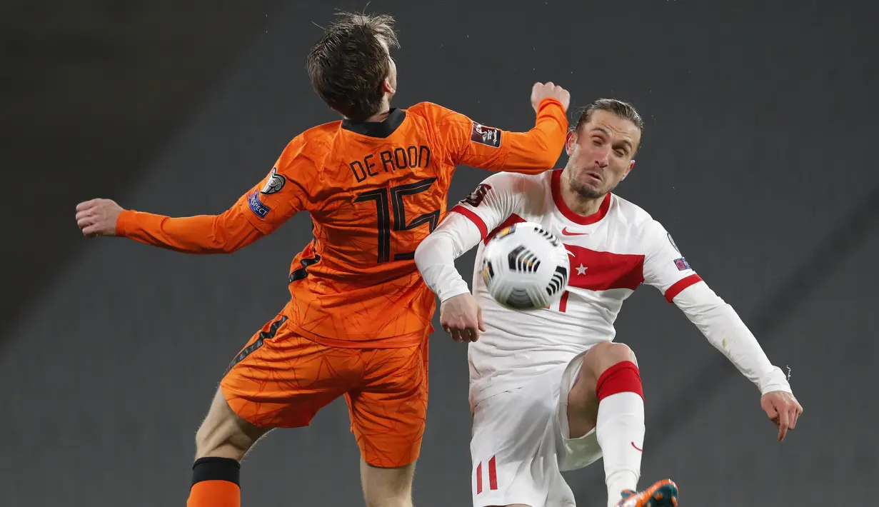 Gelandang Turki, Yusuf Yazici berebut bola dengan gelandang Belanda, Marten De Roon pada pertandingan kualifikasi Piala Dunia Grup G di Stadion Ataturk Olympic, Istanbul, Kamis (25/3/2021). Turki menang atas Belanda 4-2. (Murad Sezer/Pool Photo via AP)
