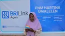 Ragaia Sosir menggunakan mesin EDC BRI untuk melayani transaksi warga di kiosnya di Kampung Arar, tempat ia menjalankan usaha sebagai BRILink Agen. (Sumber: BRI/Advertorial)