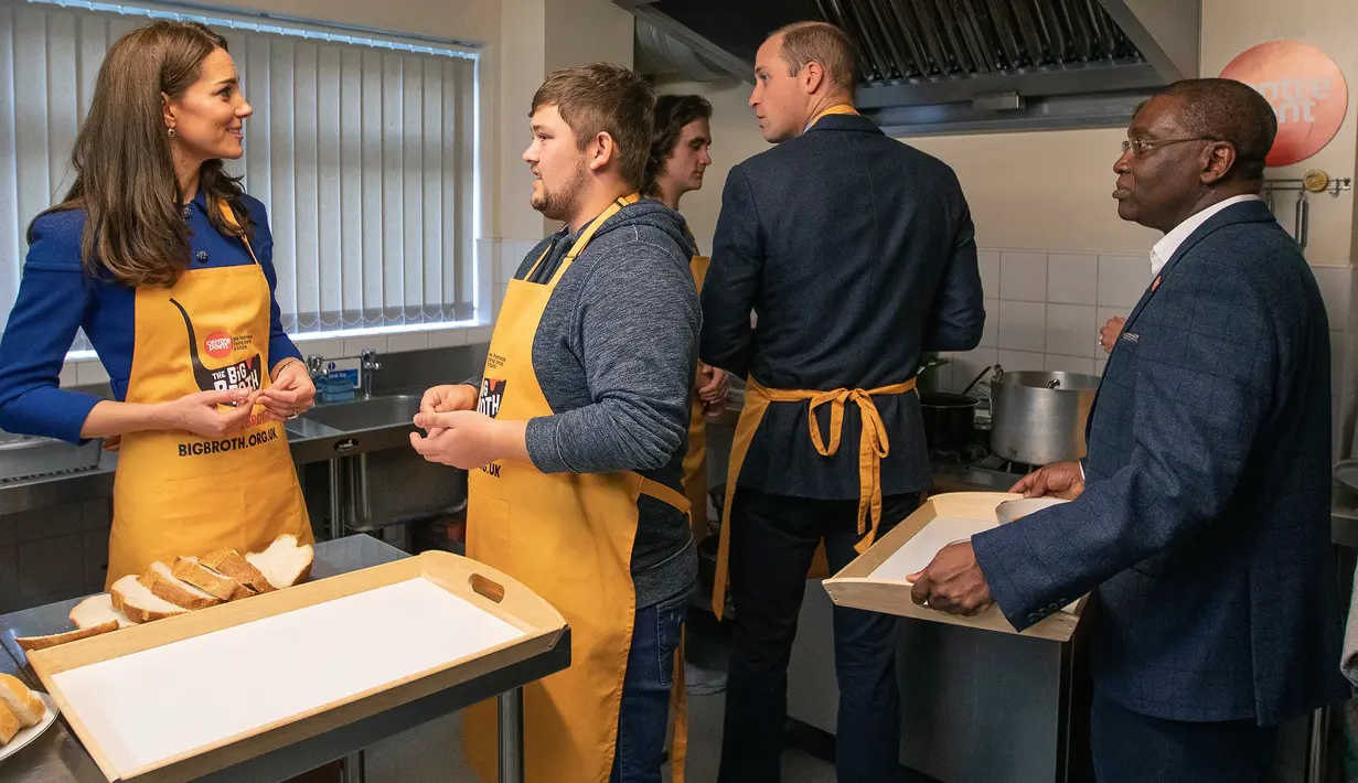 <p>Kate Middleton (kiri) dan Pangeran William (kedua kanan) menyiapkan makan siang saat mengunjungi Centrepoint di Barnsley, Inggris, Rabu (14/11). Centrepoint merupakan sebuah badan amal yang membantu para tunawisma. (Charlotte Graham/Pool via AP)</p>