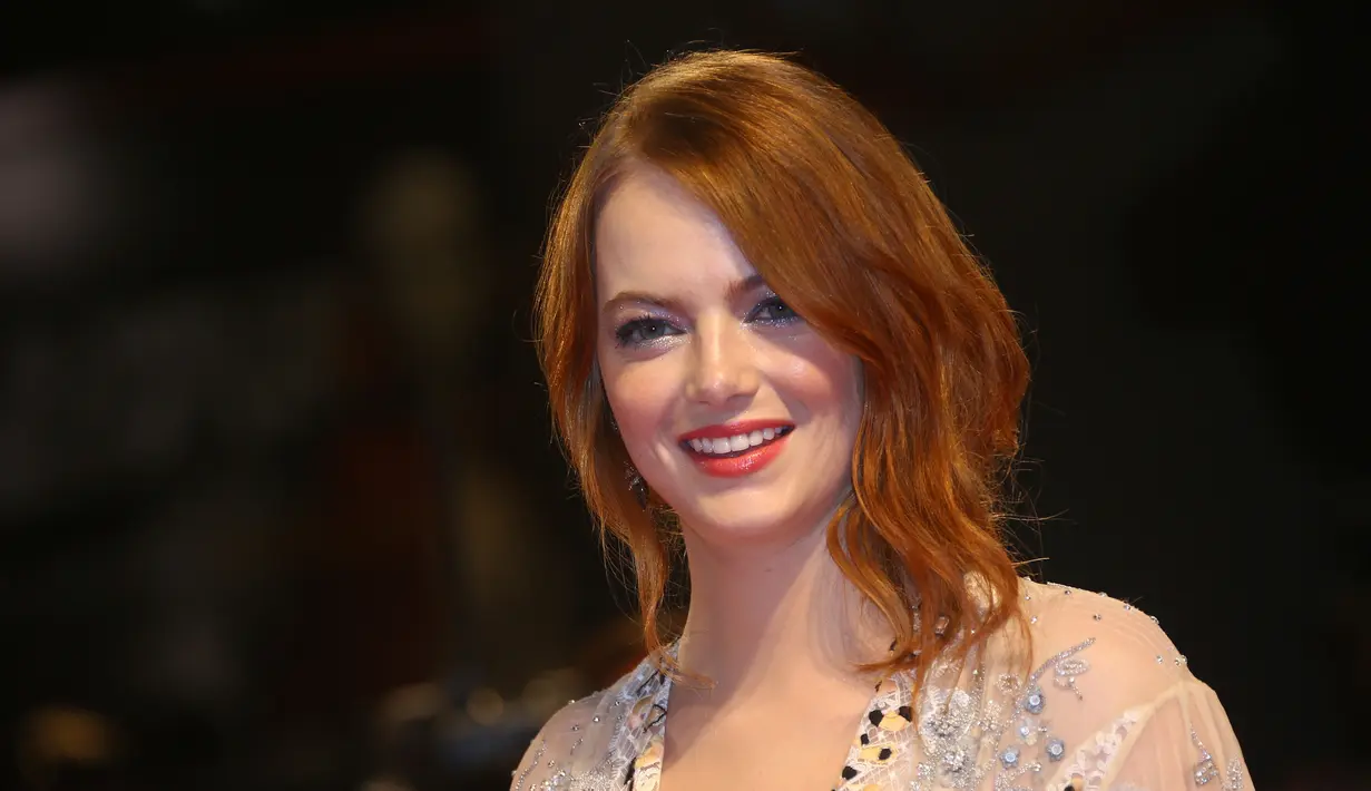 Aktris Emma Stone tersenyum saat tiba menghadiri pemutaran film "The Favorite" selama Festival Film Venice ke-75 di Venice Lido, Italia, (30/8). Emma Stone tampil cantik dengan gaun transparan warna krem. (AP Photo/Joel C Ryan)