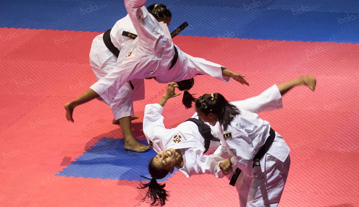Atlet kempo Bali melakukan jurus bantingan saat tampil untuk kelas embu beregu putri pada PON XIX Jawa Barat di GOR Sasana Budaya Ganesha, Bandung, Selasa (27/9/2016). (Bola.com/Vitalis Yogi Trisna)