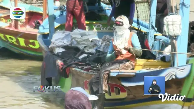 Warga Karawang bersihkan minyak mentah Pertamina yang tercecer di pesisir pantai menggunakan perahu.